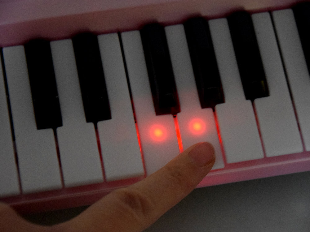Elektrinis pianinas su mikrofonu ir šviečiančiais klavišais, rožinis